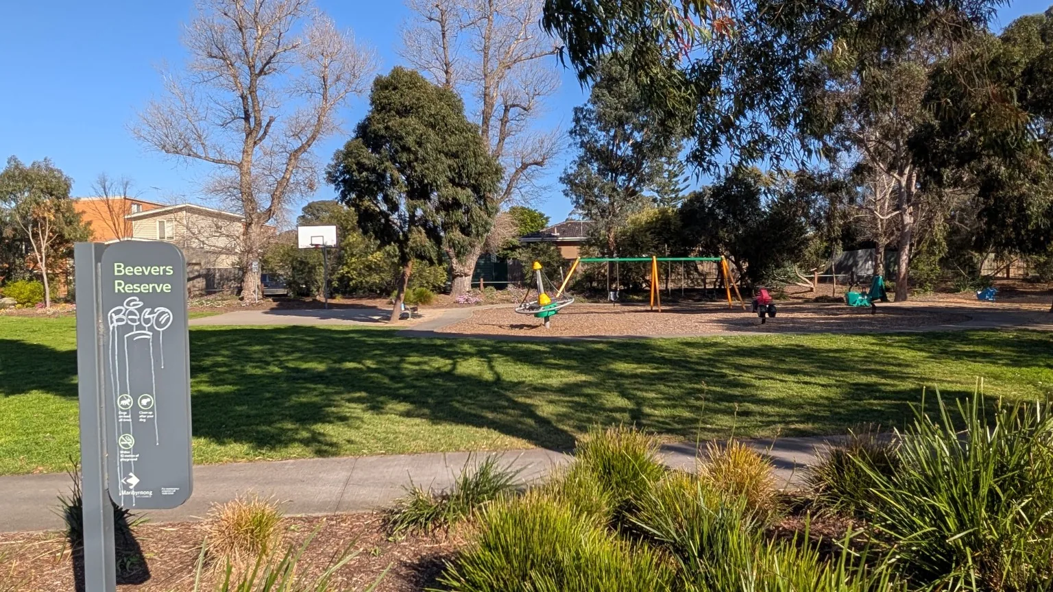 Beevers Reserve sign with the playground and open space visible behind it